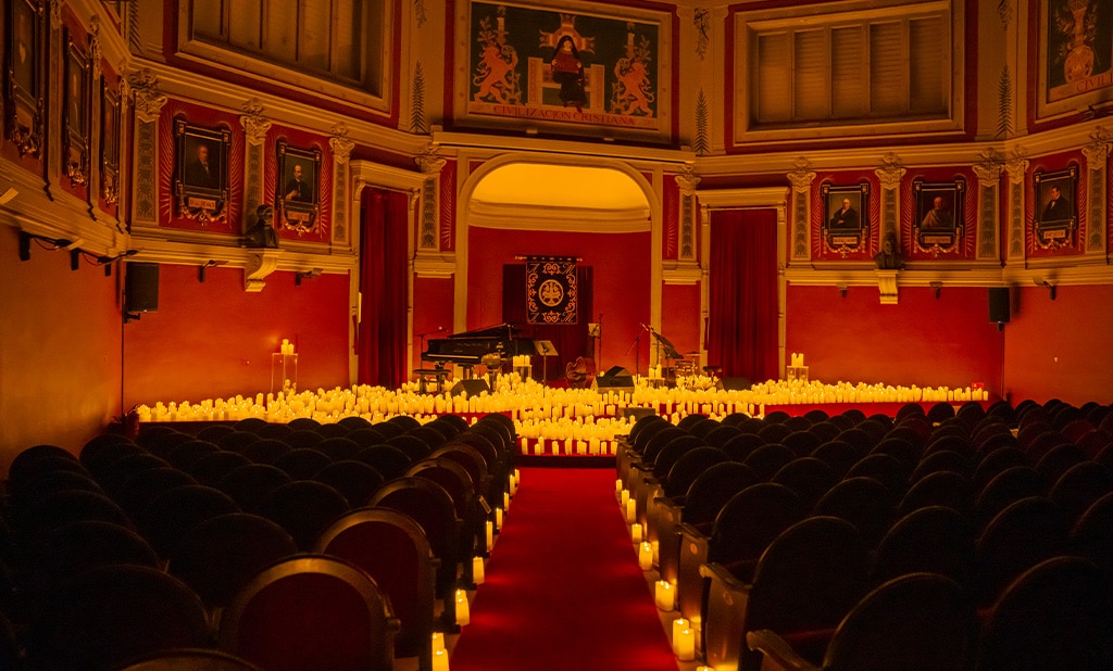 El escenario del Ateneo de Madrid con instrumentos y butacas vacías a la luz de las velas con Candlelight
