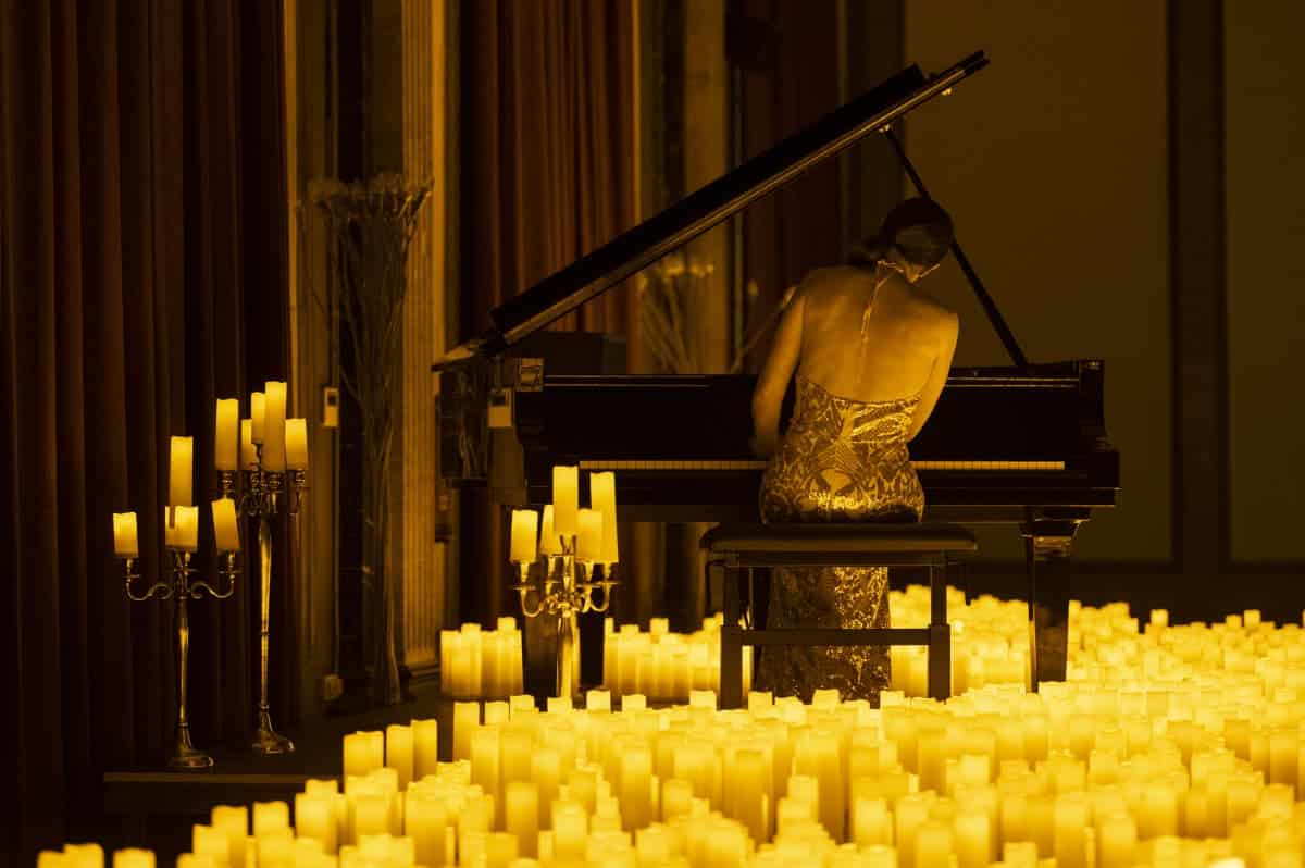 Una pianista entre velas tocando el piano 
