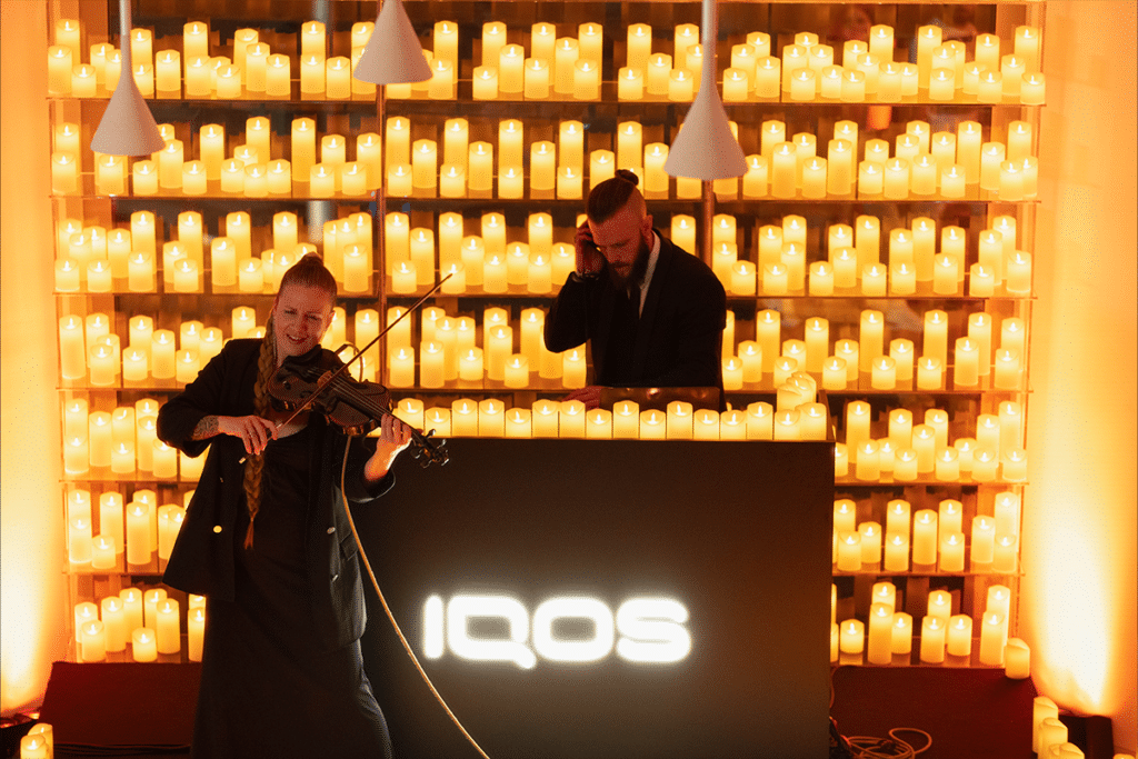Vemos a una violinista y un DJ en plena actuación rodeados de las velas de Candlelight